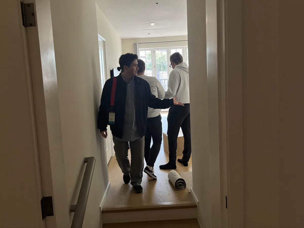 An agent leading a couple through a bright living room