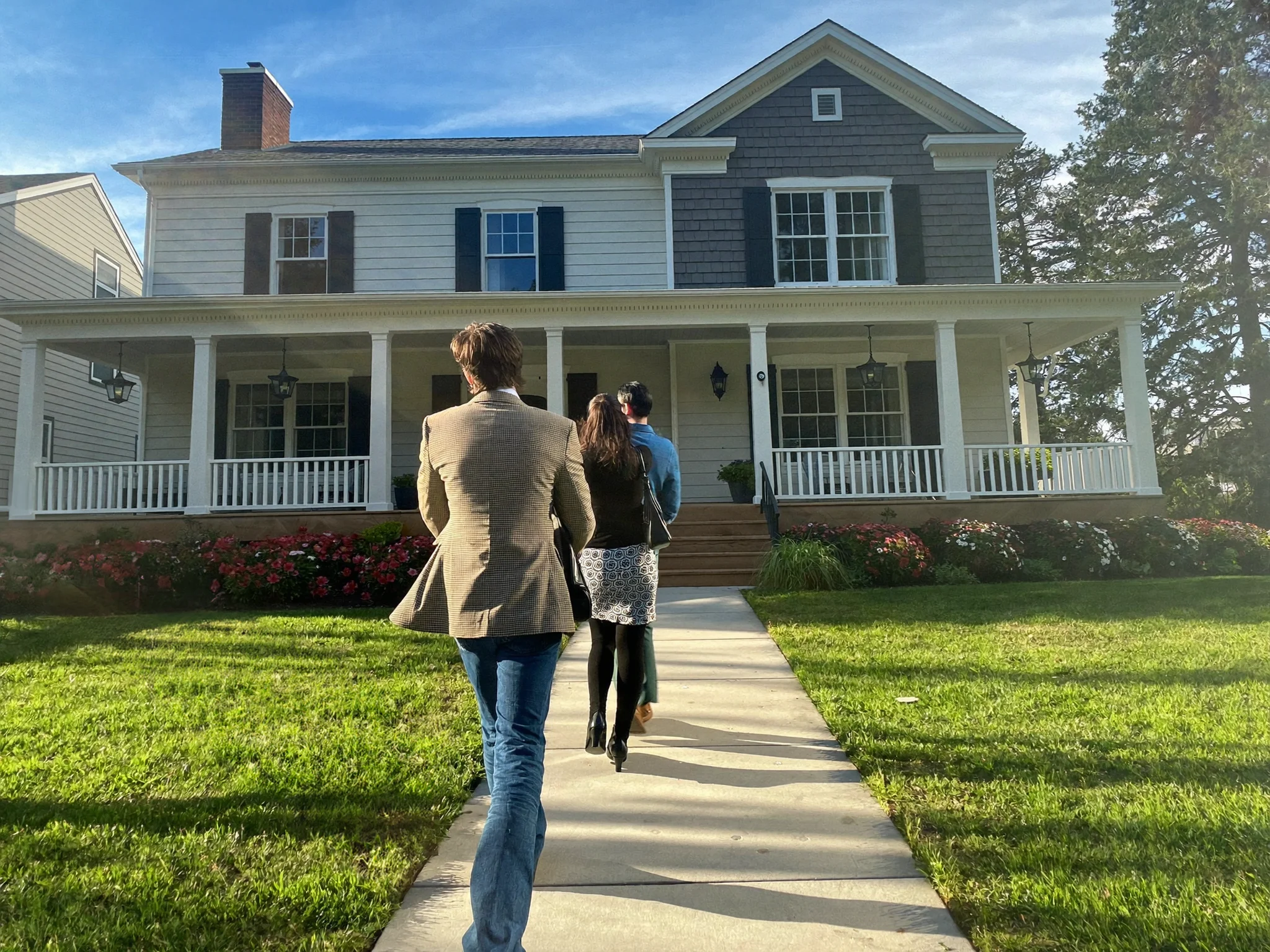 An agent arriving at a front door with clients